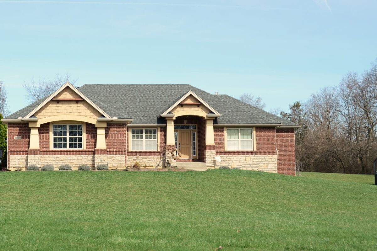 A brick ranch-style single-family house with a mown front lawn.